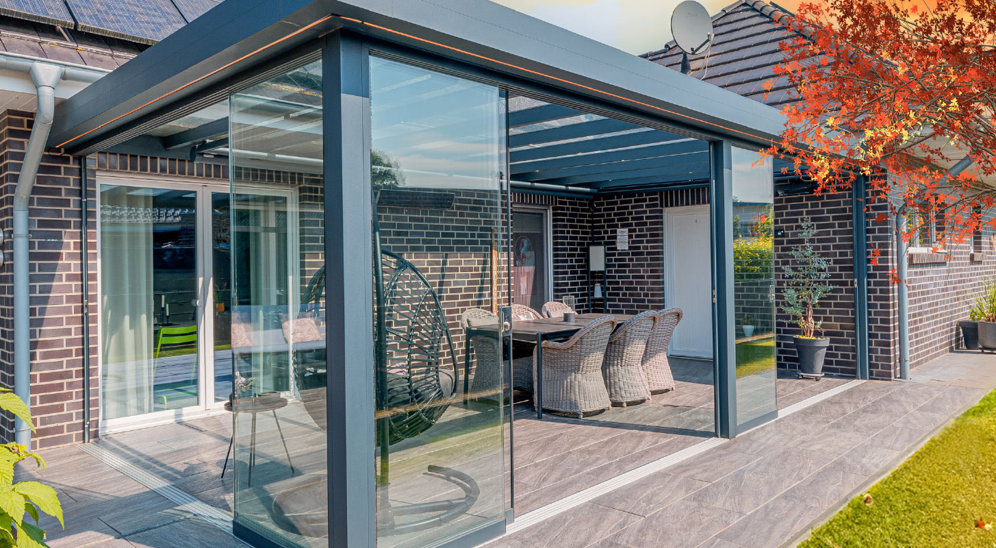 Stilvoller Kaltwintergarten mit Glasschiebewänden, der Innen- und Außenbereich harmonisch verbindet.
