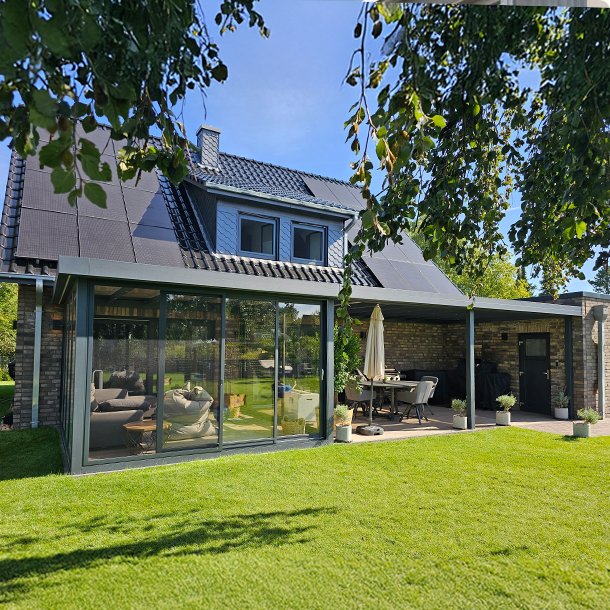 Luxus-Wintergarten mit Aluminiumprofilen und Glasfronten – lichtdurchfluteter Wohnraum mit Blick in den Garten.